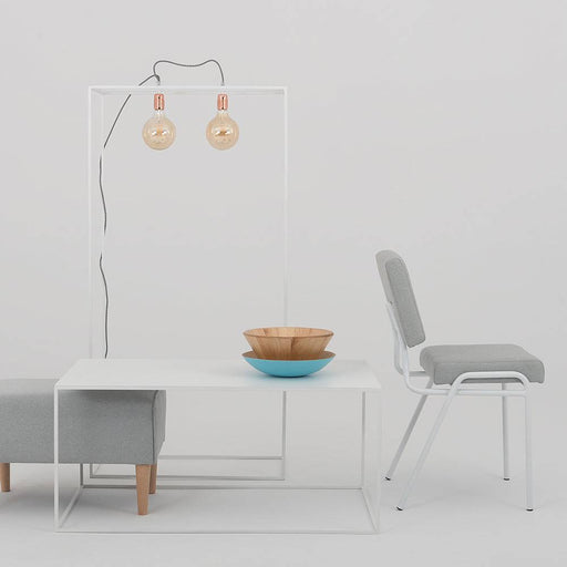 Dettaglio della sedia con rivestimento in tessuto grigio e struttura in metallo bianco, perfetta per arredamento minimalista e contemporaneo