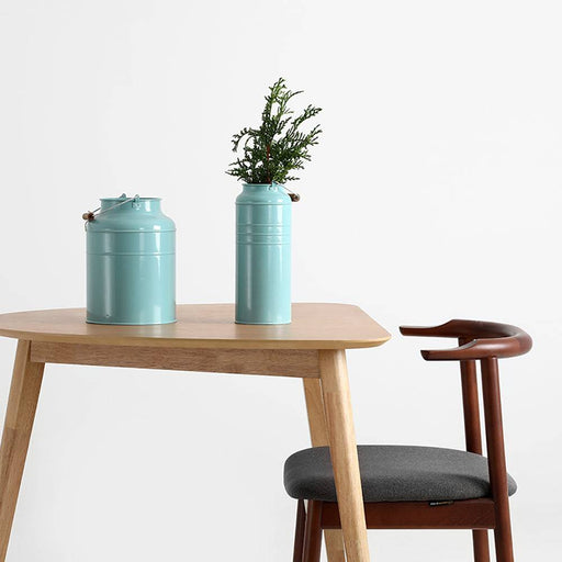 Sedia Kubrik in legno di noce con rivestimento in tessuto grigio, inserita in un ambiente con tavolo in legno e decorazioni in stile minimalista