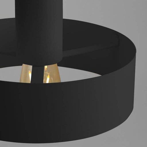 Dettaglio di lampada da soffitto nera con lampadina visibile, design semplice e funzionale, ideale per illuminazione moderna