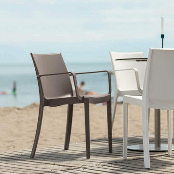 Poltrone Victoria in polipropilene taupe e bianco su terrazza vista mare, ideali per bar e ristoranti all’aperto.