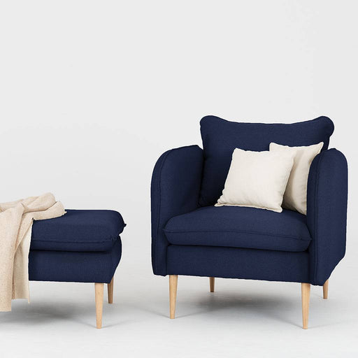 Dettaglio della poltrona in tessuto blu con cuscini bianchi, stile contemporaneo e confortevole, perfetta per ambienti eleganti