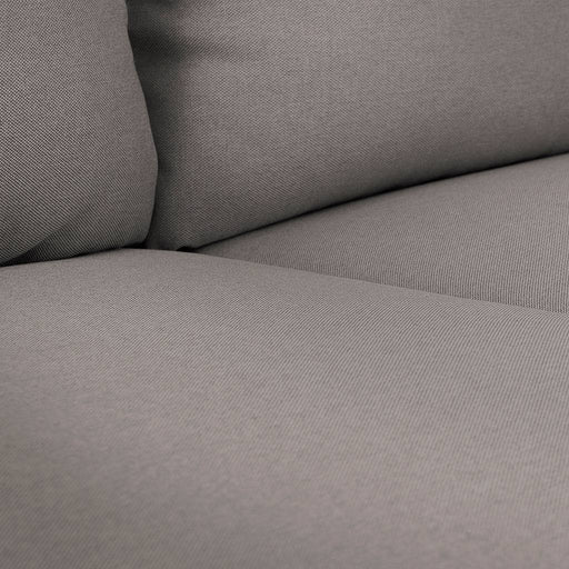 Dettaglio di tessuto grigio con trama fine, seduta e schienale imbottiti, design minimalista e confortevole.