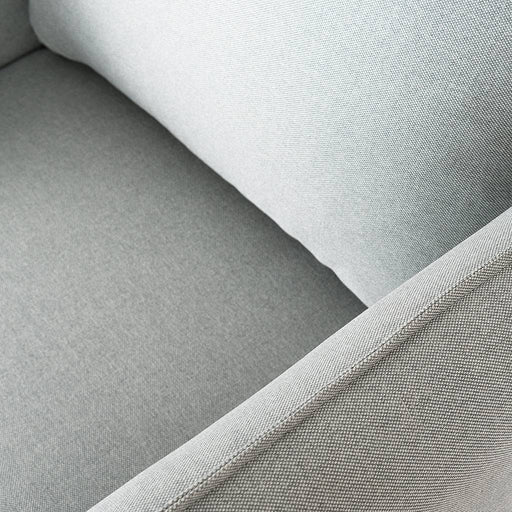 Dettaglio della poltrona in tessuto grigio chiaro con braccioli imbottiti, tessuto resistente, stile contemporaneo elegante