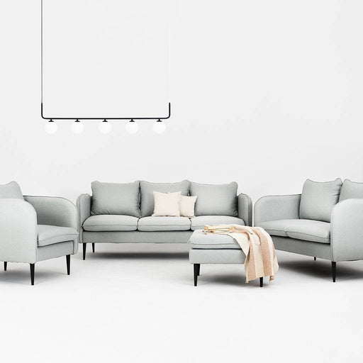 Soggiorno con divano in tessuto grigio chiaro, grande spazio di seduta, con tavolino coordinato, ambiente minimalista e luminoso.