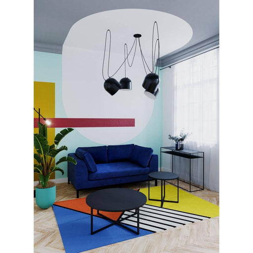 Ambientazione con console metallica nera Tensio 100x35, posizionata in soggiorno con divano blu, tavolini neri e decorazioni colorate, stile moderno.