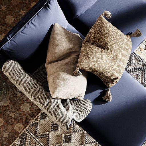 Divano angolare in tessuto blu scuro con cuscini coordinati, stile moderno, piedi in legno chiaro, ideale per soggiorno elegante e confortevole
