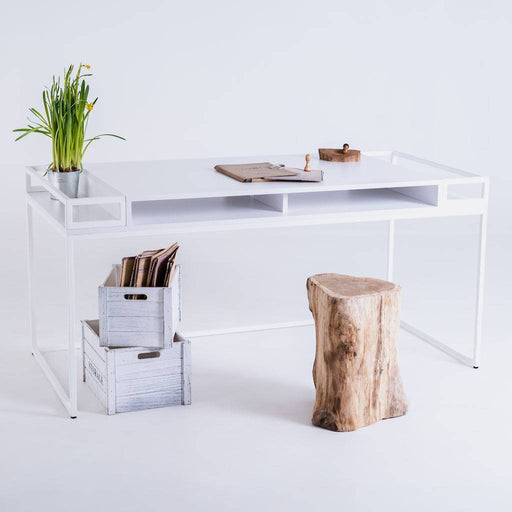 Scrivania bianca moderna con superficie liscia, decorata con piante e oggetti, perfetta per un ambiente di lavoro minimalista.