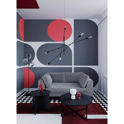 Interno con divano a due posti con rivestimento in tessuto check nero e bianco, pareti decorate con motivi geometrici, stile contemporaneo