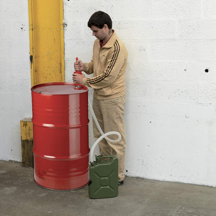 Pompa travaso manuale in uso per trasferire liquidi da un grande serbatoio rosso a una tanica verde, adatta per liquidi sotto 50°C.