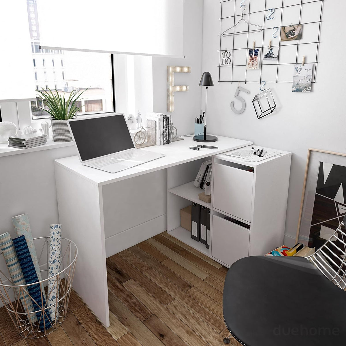 Scrittoio bianco opaco in un ambiente moderno con finestra, laptop e accessori. Design reversibile e compatto per spazi di lavoro eleganti.