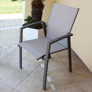 Poltrona Maili grigia con braccioli in alluminio su terrazza, ideale per arredamento da esterno elegante e funzionale.