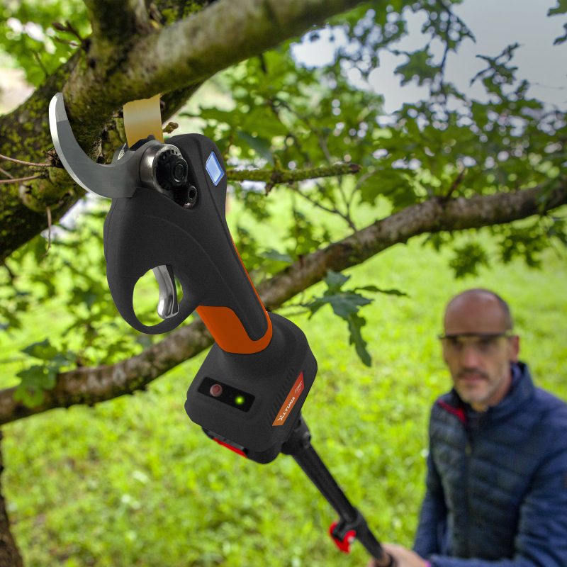 Tagliabordo a batteria con lama curva in acciaio, impugnatura ergonomica nera e arancione, in uso su albero, SKU: ALTUNA-AF37