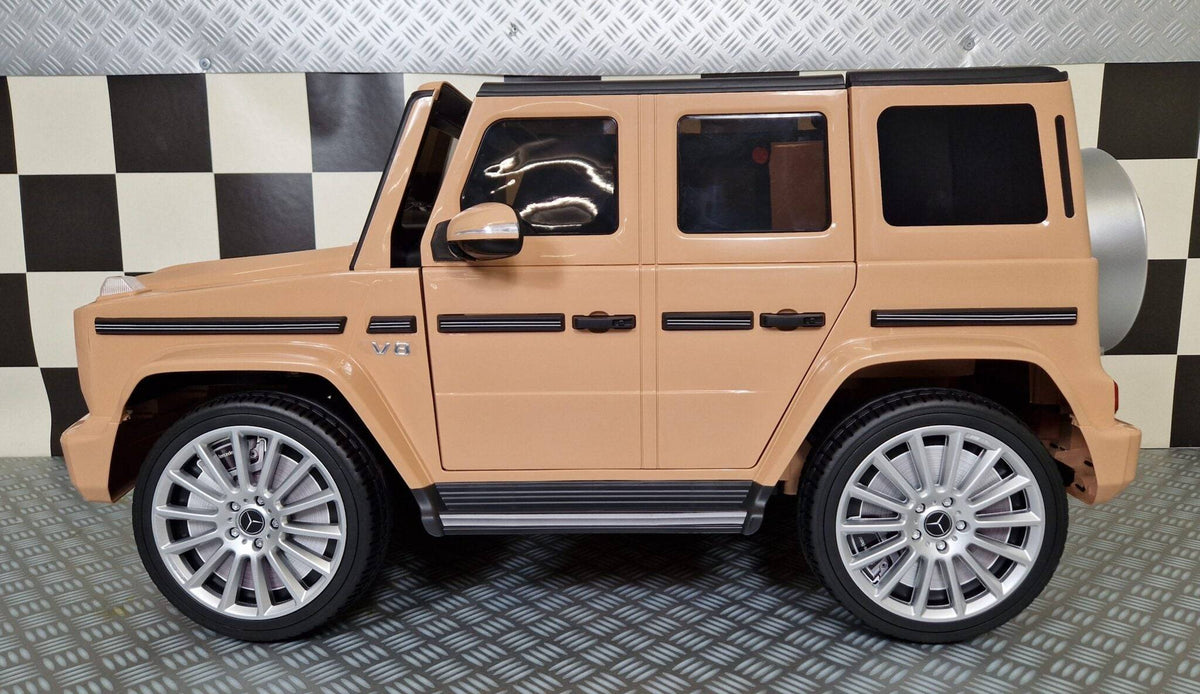 Vista laterale dell'auto elettrica per bambini Mercedes G500 colore sabbia con dettagli autentici e ruote di alta qualità