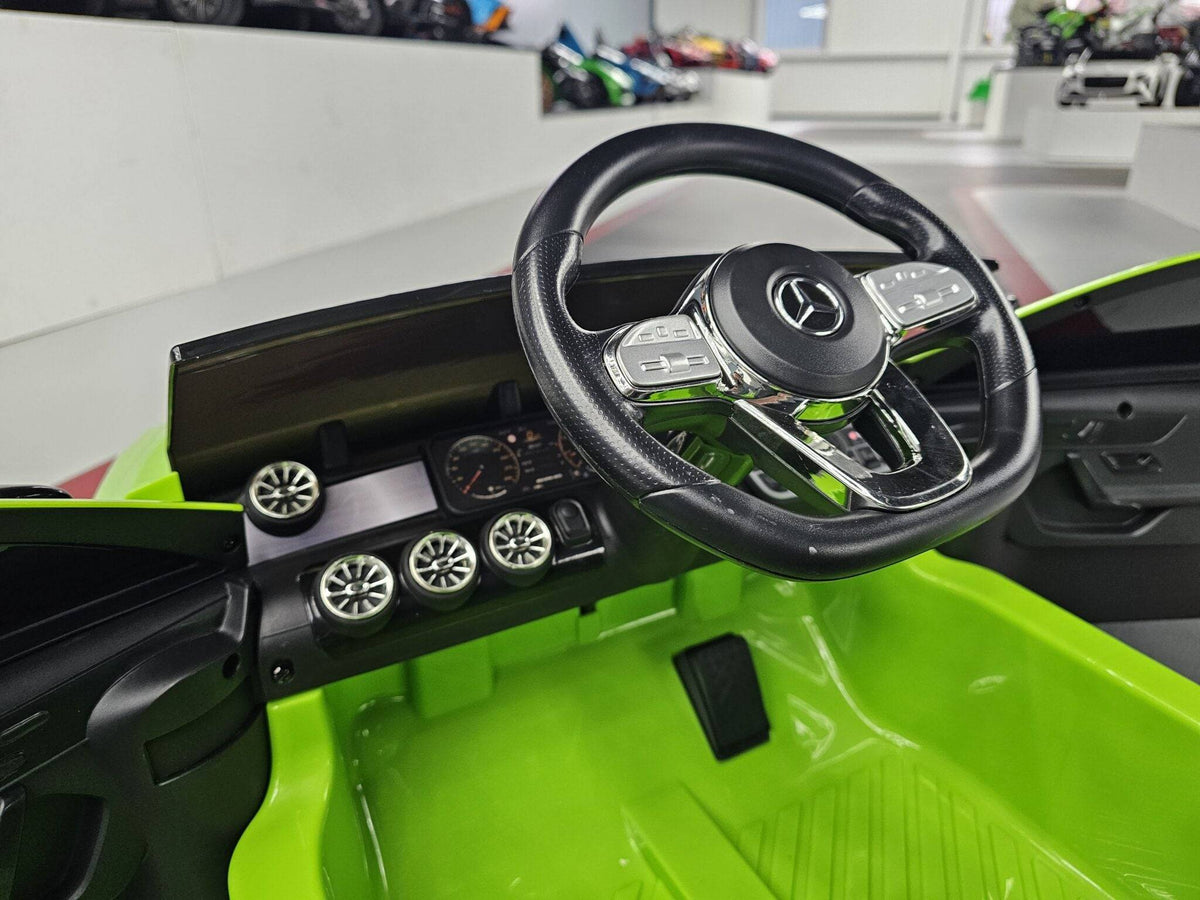 Auto elettrica per bambini Mercedes CLA 45 verde con volante nero e dettagli cromati, sedile in similpelle nera, perfetta per divertimento