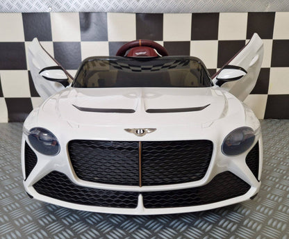 Auto elettrica per bambini Bentley Bacalar bianca con portiere aperte, dettagli in marrone e sedile rosso, luci posteriori accese, stile sportivo