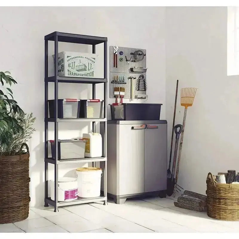 Stilo Cabinet Low in resina grigio scuro posizionato in un ambiente organizzato con scaffali e attrezzi, ideale per spazi interni.
