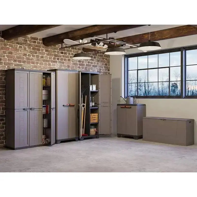 Set di mobili in resina grigio scuro, incluso Stilo Cabinet Low, in un ampio spazio con pareti in mattoni e finestre luminose.