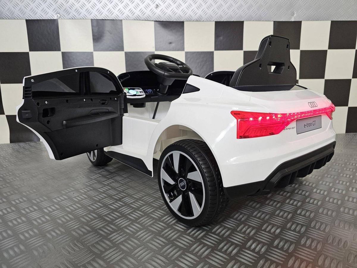 Vista posteriore dell'auto elettrica per bambini Audi E-Tron bianca con luci LED rosse, dettagli neri, portiere aperte e design realistico