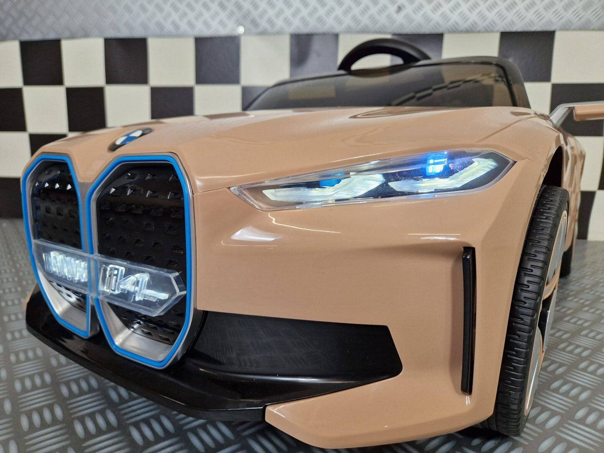 Vista frontale dell'auto elettrica per bambini BMW i4, con dettagli del cofano e luci LED, in colore champagne