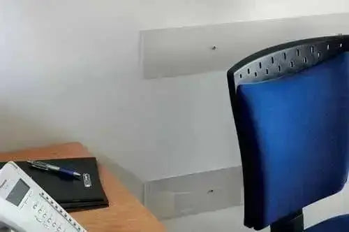 Battisedia trasparente per sedie e poltrone con viti e tasselli 80x12 fissato a parete in un ufficio moderno. Protezione ideale per muri e garage.