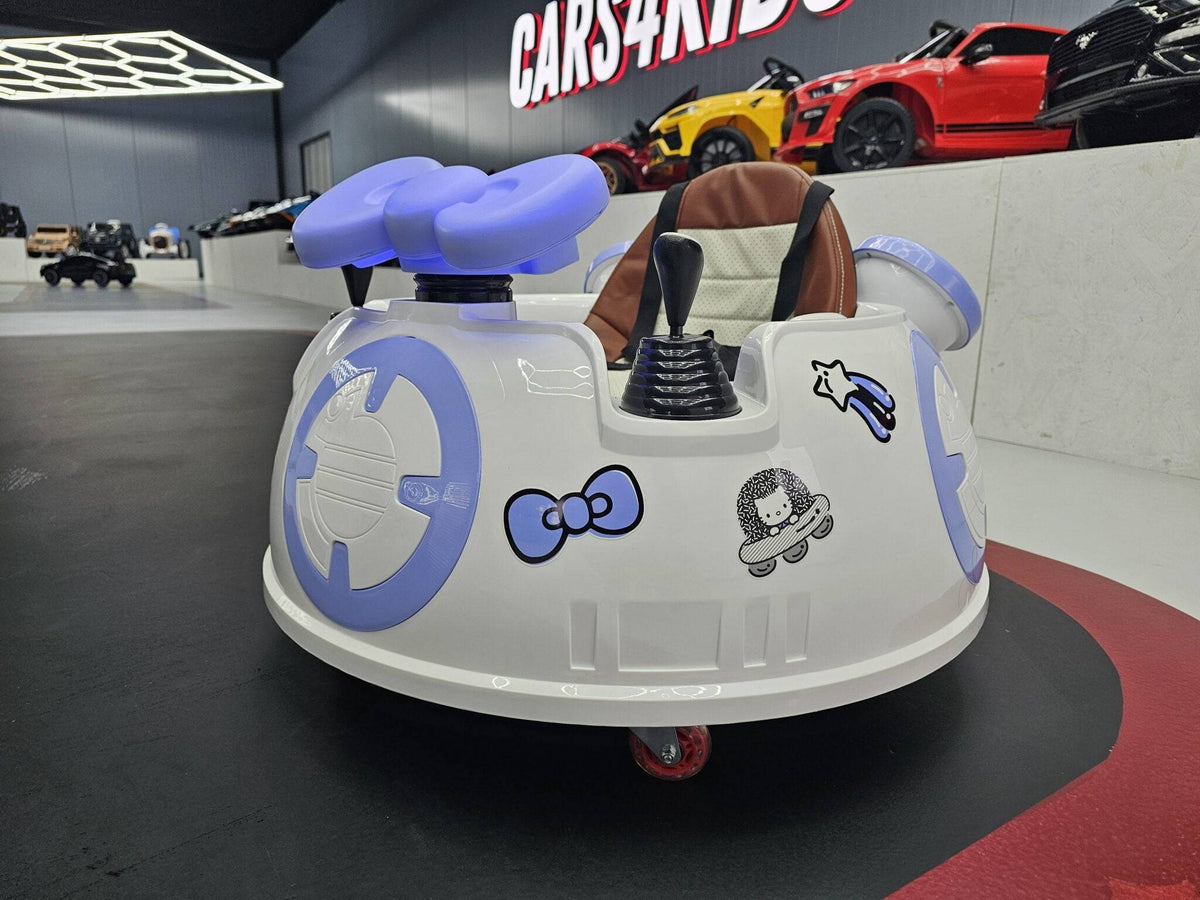 Auto per bambini con volante e sedile in pelle marrone, dettagli decorativi con personaggi e simboli spaziali, in un'area espositiva