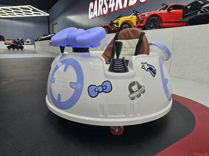 Auto per bambini con volante e sedile in pelle marrone, dettagli decorativi con personaggi e simboli spaziali, in un'area espositiva