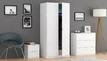 Comodino bianco 2 cassetti 38x34x45H abbinato ad armadio e cassettiera in una stanza moderna con decorazioni minimaliste.