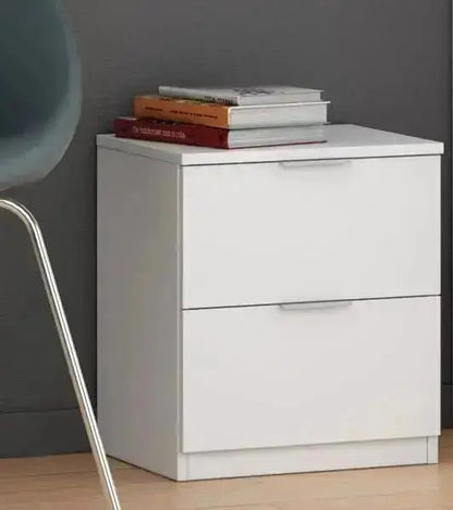 Comodino bianco 2 cassetti 38x34x45H posizionato accanto a una sedia moderna, perfetto per arredare spazi contemporanei.