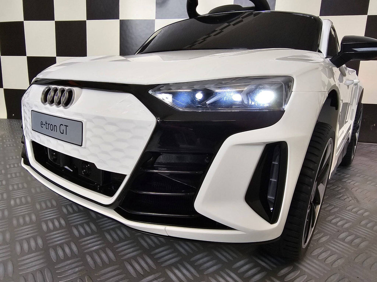 Interno dell'auto elettrica per bambini Audi E-Tron, volante con logo Audi, pannello di controllo digitale e sedile nero con cinturino di sicurezza