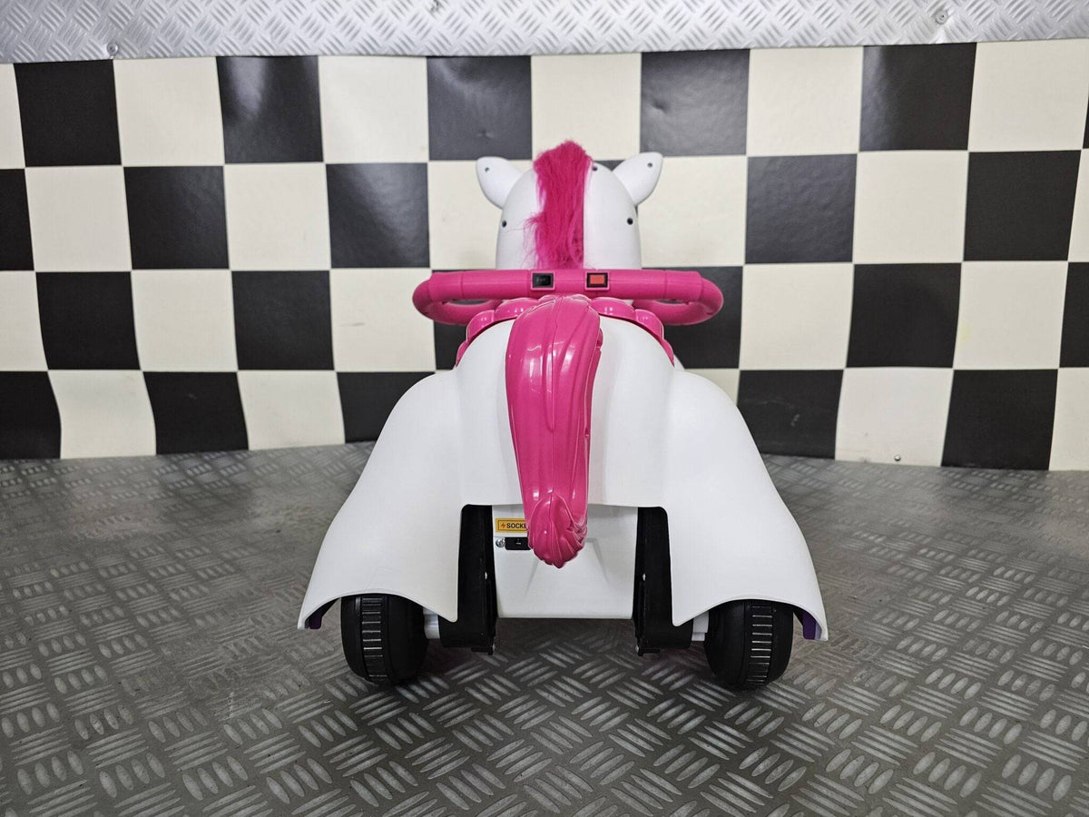 Retro del cavallo a dondolo unicorno con criniera rosa, corno blu e sella rosa, in posizione di riposo, sfondo a scacchi bianco e nero