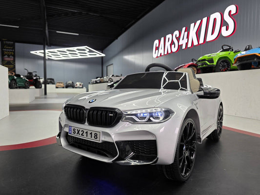 Auto elettrica per bambini BMW M5 24 V colore grigio metallizzato con sedile beige, dettagli realistici e dimensioni compatte, ideale per giochi all'aperto