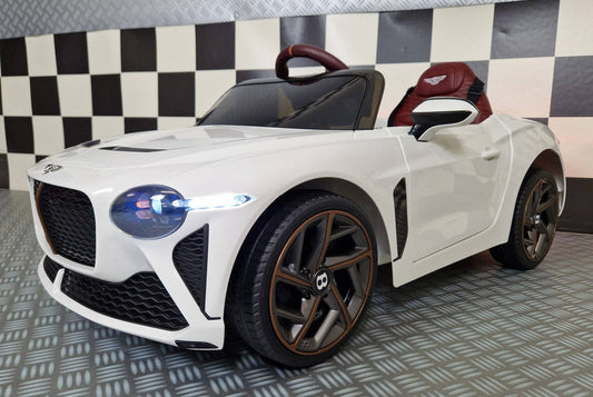 Vista dall'alto dell'auto elettrica per bambini Bentley Bacalar bianca con volante e sedile rosso, dettagli in marrone, luci posteriori accese