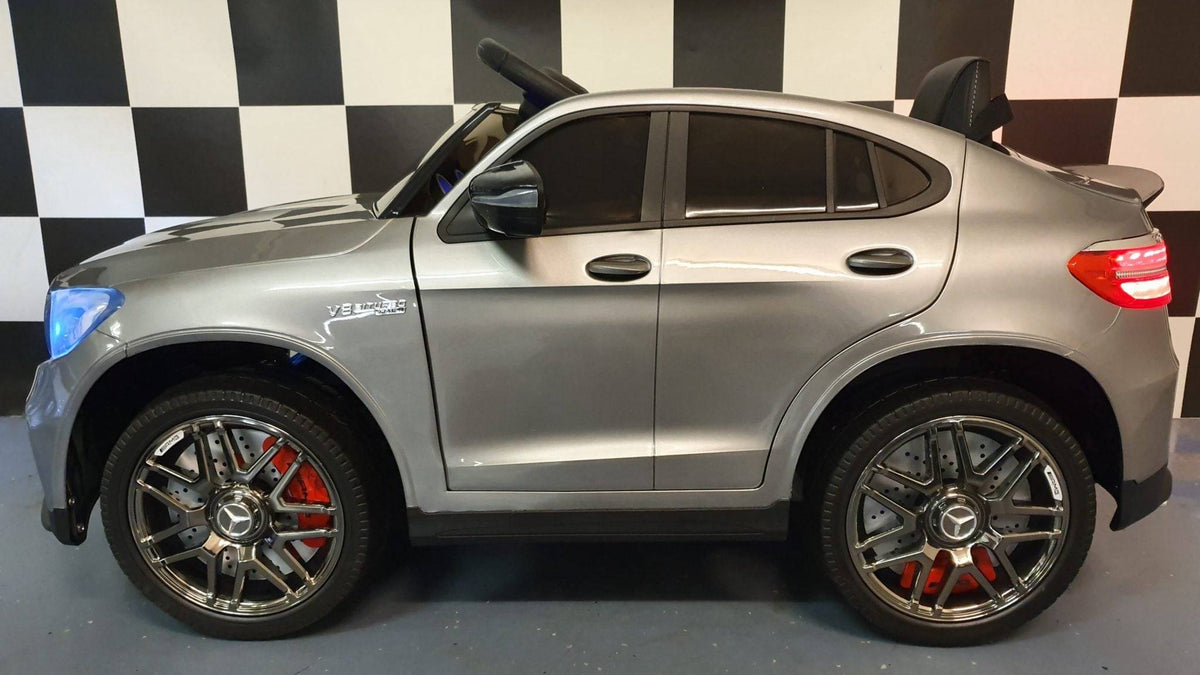Auto elettrica per bambini Mercedes GLC 63 AMG, vista posteriore con luci rosse e spoiler, in colore grigio metallizzato, stile realistico