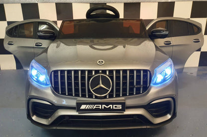 Auto elettrica per bambini Mercedes GLC 63 AMG, vista dall'alto con volante e sedili, in colore grigio metallizzato, dettagli di lusso