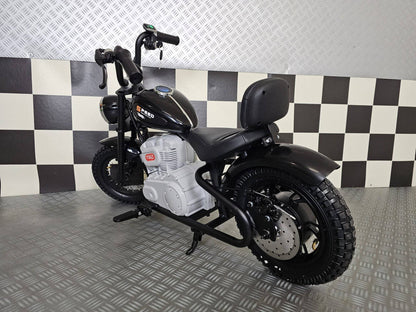 Vista frontale della moto elettrica per bambini modello chopper nero, con grande faro rotondo, manubrio alto e dettagli in stile motociclista.