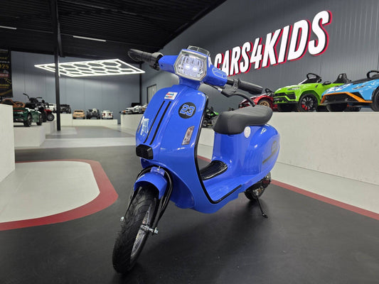 Moto elettrica per bambini blu con luci LED frontali, sedile nero, pneumatici robusti e design sportivo, ideale per divertenti avventure