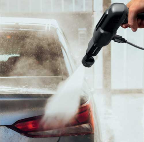 Utente che utilizza l'idropulitrice portatile Innoliving per lavare l'auto, con corpo nero e ugello rotante, senza fili e ricaricabile.