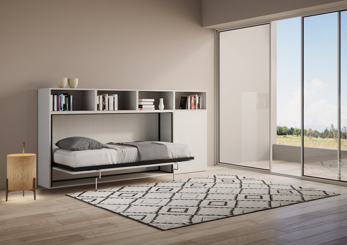 Letto Kando aperto con materasso singolo, integrato in una parete attrezzata moderna con libreria, ideale per monolocali.