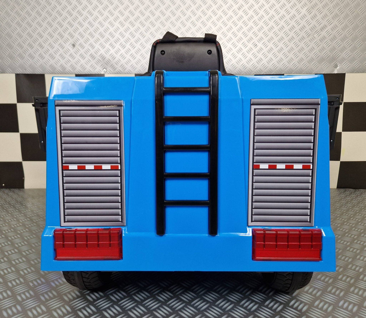 Auto dei poliziotti per bambini in plastica blu con luci lampeggianti rosse e blu, volante e sedile nero con cinture di sicurezza, dimensioni compatte.