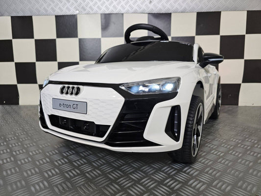 Auto elettrica per bambini Audi E-Tron bianca con dettagli neri, fari LED, volante e sedile di plastica, dimensioni compatte, per divertimento sicuro