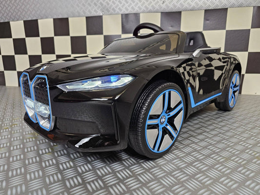 Vista frontale dell'auto elettrica per bambini BMW i4 nera con fari LED, griglia anteriore dettagliata e logo BMW, SKU: c4k1009 zwart