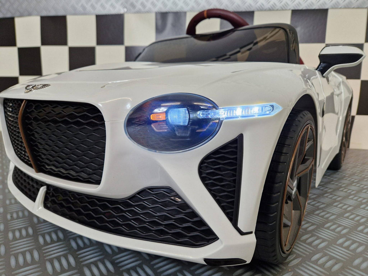 Interno dell'auto elettrica per bambini Bentley Bacalar, volante color burgundy con logo Bentley, pannello strumenti digitale e dettagli realistici.