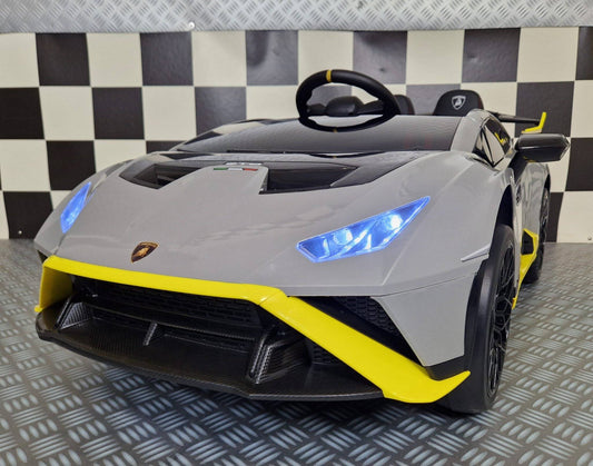 Auto elettrica per bambini Lamborghini Huracan STO 12 V grigia con dettagli sportivi, fari LED blu, volante e sedili in ecopelle, dimensioni compatte.