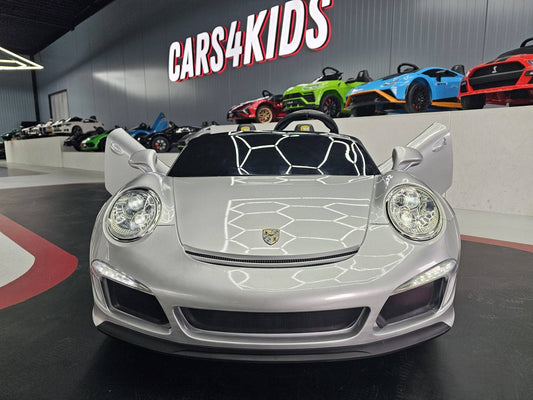 Vista frontale dell'auto elettrica per bambini Porsche RUF 24 V in argento metallizzato, con fari, cofano e dettagli di alta qualità, ideale per i giochi all'aperto.