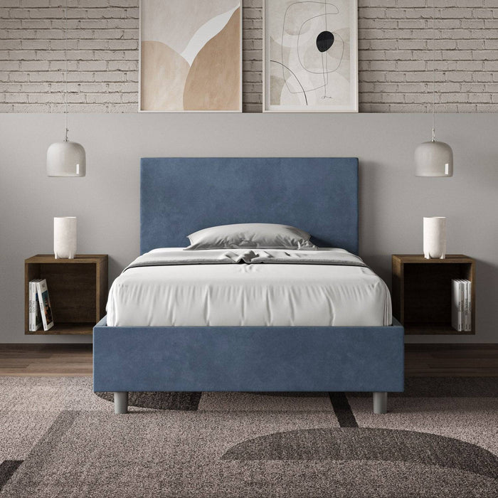 Letto singolo contenitore imbottito 100x210 microfibra Adele blu navy in camera moderna con decorazioni minimal e parete in mattoni.