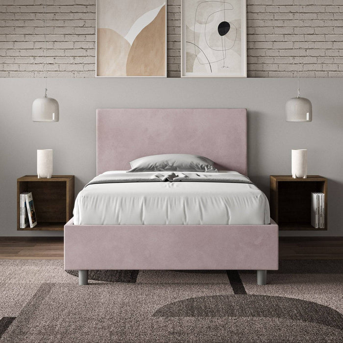 Letto singolo contenitore imbottito 100x210 microfibra Adele rosa cipria in camera moderna con parete in mattoni e decorazioni astratte.