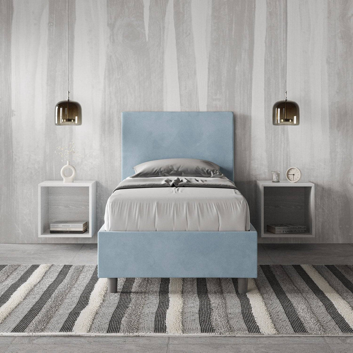 Letto singolo contenitore imbottito 90x200 microfibra Adele azzurro chiaro in camera moderna. Arredo elegante con comodini sospesi e tappeto a righe.