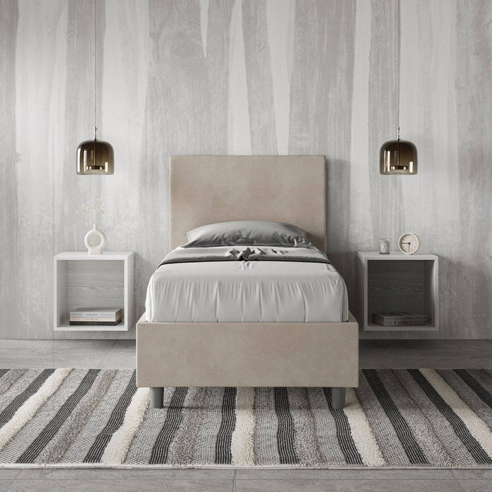 Letto singolo Adele 90x210 in microfibra beige con contenitore, ambientato in una camera elegante con comodini sospesi.