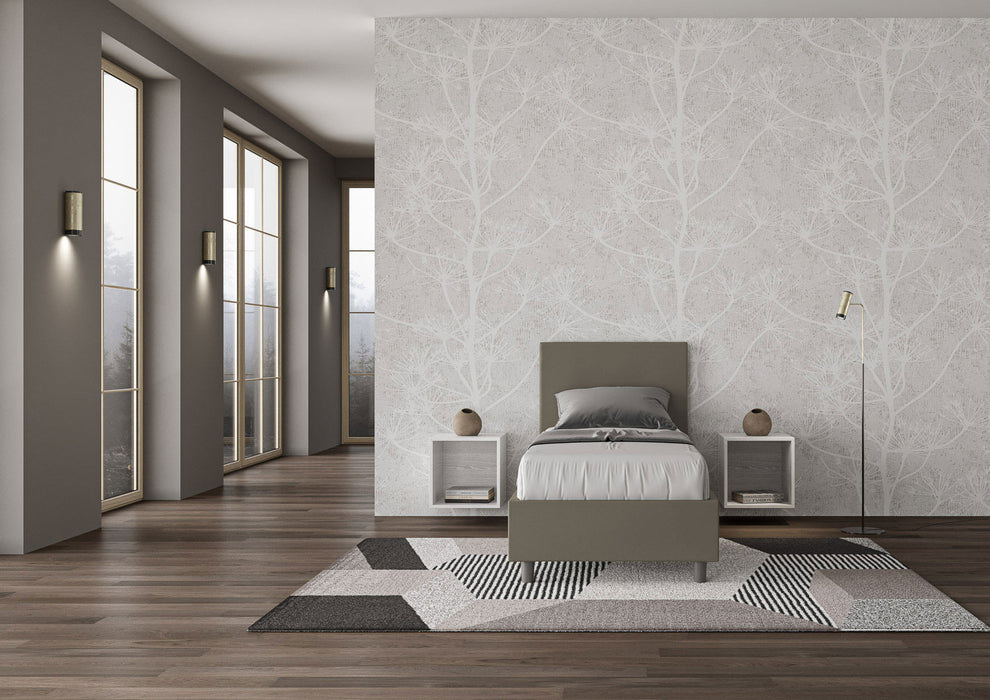 Letto singolo Adele grigio-verde in similpelle con struttura imbottita, in una stanza luminosa con pareti chiare e pavimento in legno.