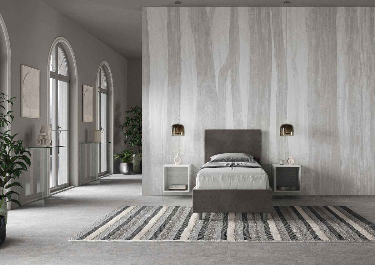 Letto singolo contenitore imbottito 90x200 microfibra Adele grigio scuro in ampio ambiente luminoso. Perfetto per arredare camere minimaliste.